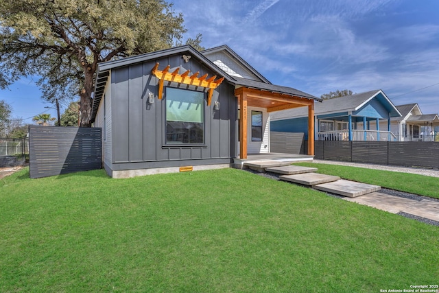 view of front of home featuring a front lawn, fence, and board and batten siding