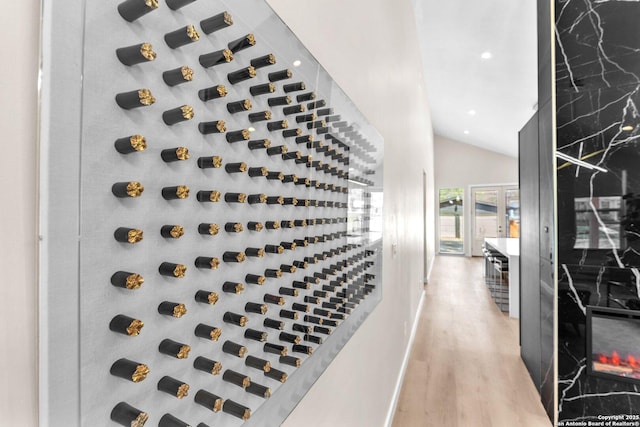 wine area featuring recessed lighting, light wood-type flooring, baseboards, and vaulted ceiling