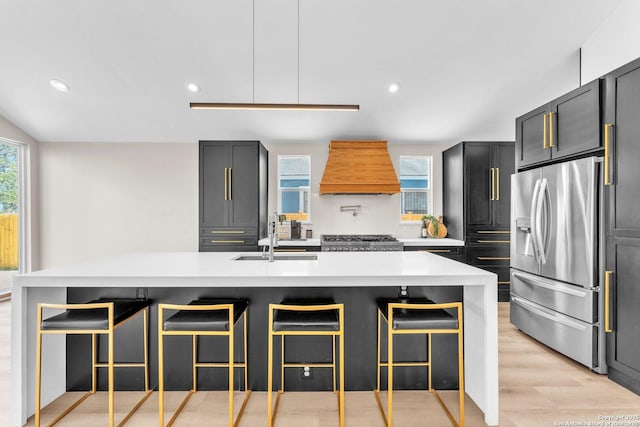 kitchen with stainless steel refrigerator with ice dispenser, a sink, light countertops, range, and custom exhaust hood