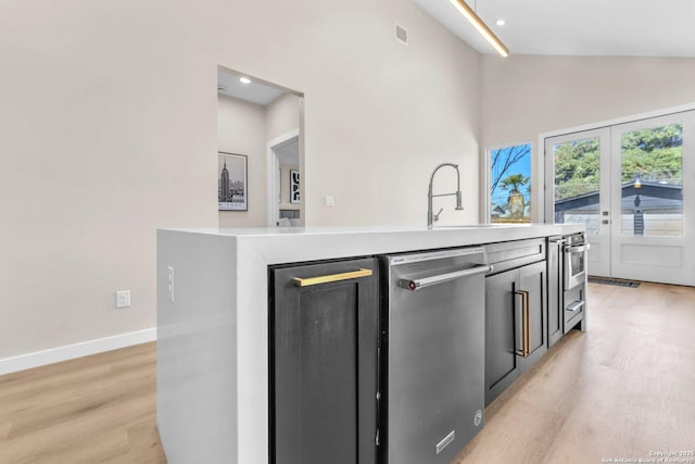 kitchen featuring visible vents, light wood finished floors, baseboards, light countertops, and appliances with stainless steel finishes