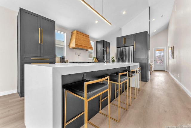 kitchen featuring light wood finished floors, stainless steel fridge, and light countertops