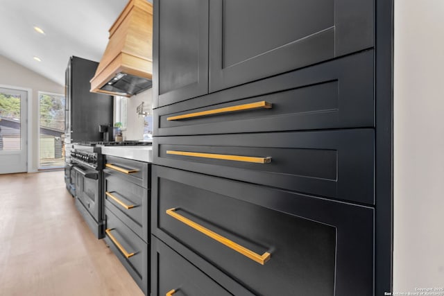 kitchen with high end range, recessed lighting, custom range hood, and vaulted ceiling