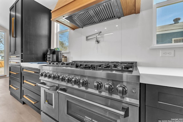 kitchen with range with two ovens and custom range hood