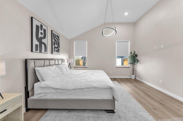 bedroom featuring vaulted ceiling, wood finished floors, and baseboards