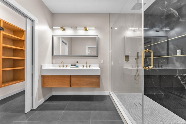 bathroom with tile patterned flooring, baseboards, double vanity, a stall shower, and a sink