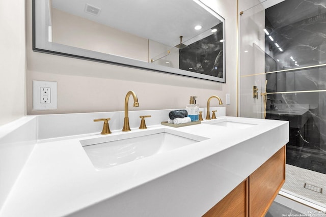 bathroom with double vanity, a walk in shower, visible vents, and a sink