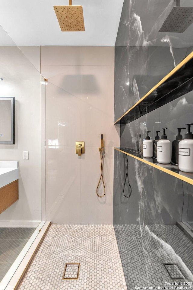 bathroom with tile patterned flooring, tile walls, an enclosed shower, and vanity