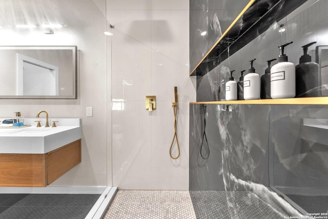 bathroom with tile patterned floors, a marble finish shower, and vanity