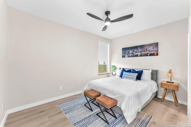 bedroom featuring light wood-style floors, baseboards, and ceiling fan