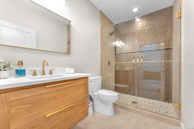 bathroom with tile patterned floors, toilet, a stall shower, and vanity