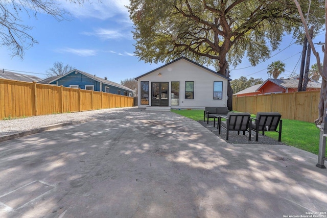 back of property featuring an outdoor hangout area, a fenced backyard, and a patio area