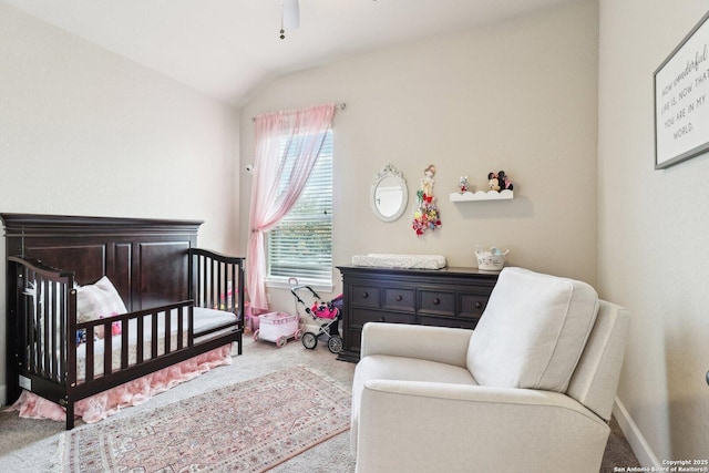 bedroom with baseboards, a crib, carpet floors, and vaulted ceiling