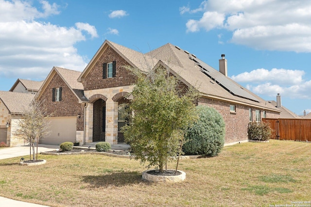 view of front of house with stone siding, brick siding, a front lawn, and fence