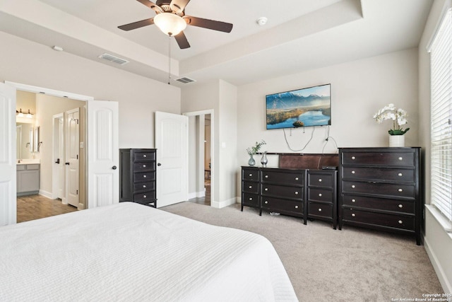 bedroom featuring visible vents, a raised ceiling, carpet, and baseboards