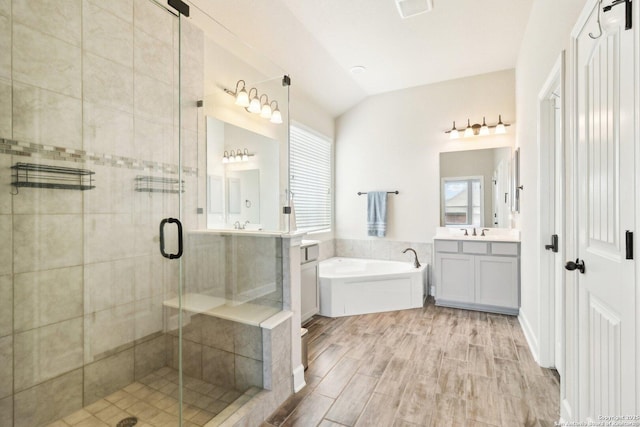 bathroom featuring visible vents, a shower stall, lofted ceiling, a bath, and vanity