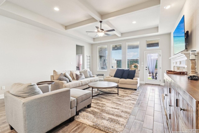 living area with baseboards, beam ceiling, coffered ceiling, and ceiling fan