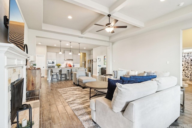 living room with beamed ceiling, light wood-type flooring, recessed lighting, coffered ceiling, and a ceiling fan