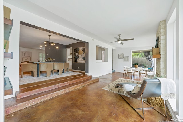 living room with ceiling fan and finished concrete flooring