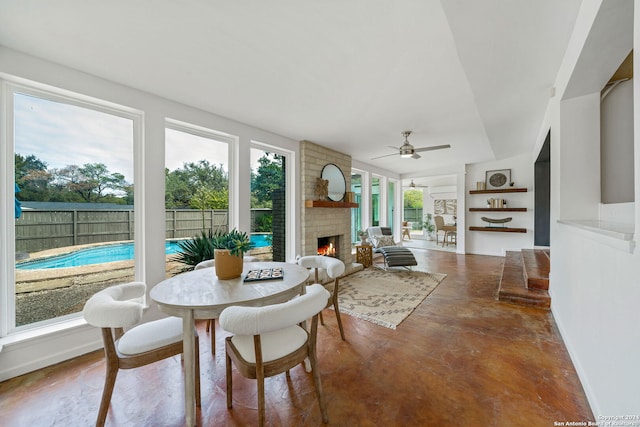 sunroom featuring a fireplace and a ceiling fan