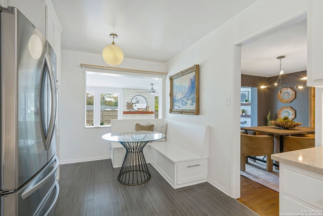 dining area with baseboards and dark wood-type flooring