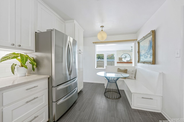 kitchen with breakfast area, decorative backsplash, baseboards, and white cabinetry