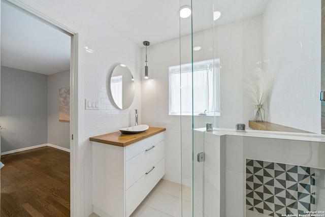 bathroom featuring wood finished floors, a stall shower, and vanity