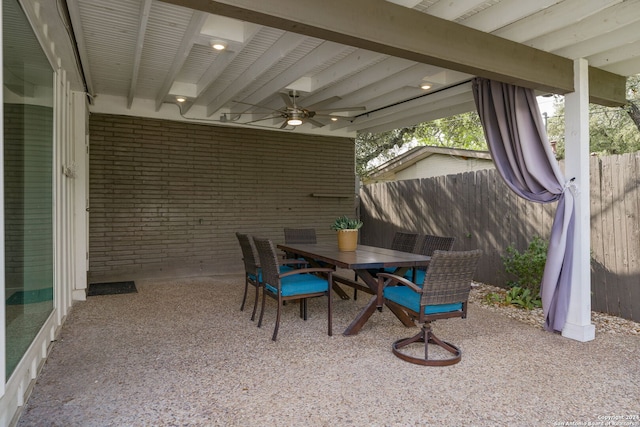 view of patio featuring outdoor dining area, ceiling fan, and fence