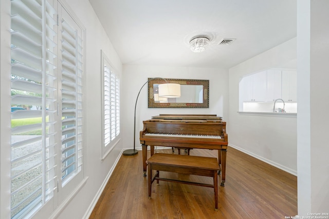 sitting room featuring a notable chandelier, wood finished floors, visible vents, and baseboards