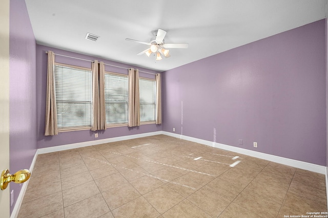 empty room with tile patterned flooring, baseboards, visible vents, and ceiling fan