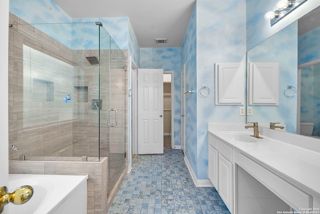 bathroom with visible vents, a shower stall, baseboards, a garden tub, and vanity