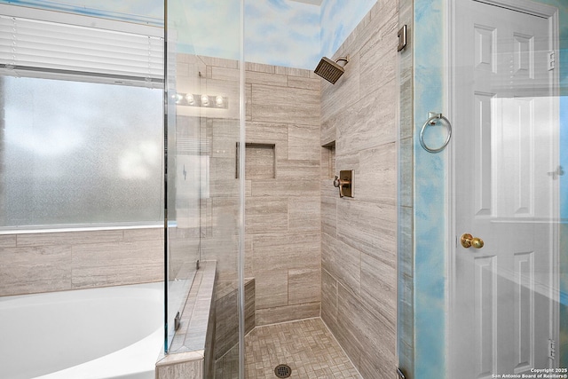 full bathroom featuring a shower stall and a garden tub