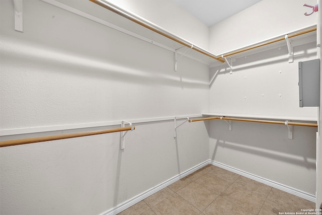 walk in closet featuring electric panel and light tile patterned flooring