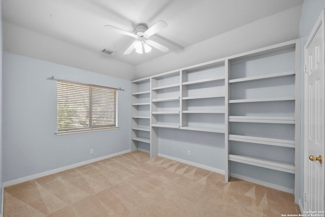 walk in closet with visible vents, carpet floors, and ceiling fan