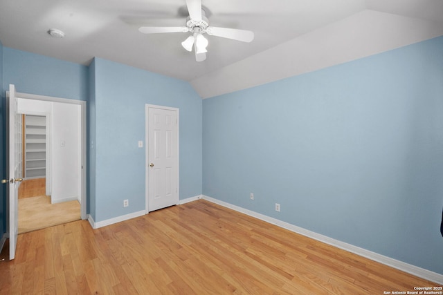 unfurnished bedroom with baseboards, light wood-type flooring, lofted ceiling, and a ceiling fan