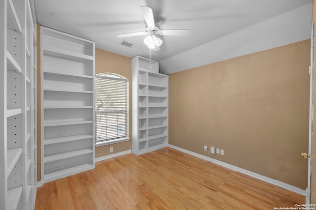 unfurnished bedroom featuring wood finished floors, visible vents, baseboards, ceiling fan, and vaulted ceiling