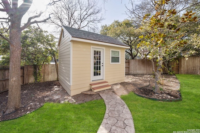 view of outdoor structure featuring entry steps, an outdoor structure, and a fenced backyard