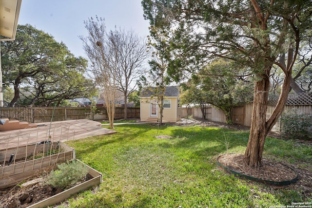 view of yard with a patio, an outbuilding, a vegetable garden, and a fenced backyard