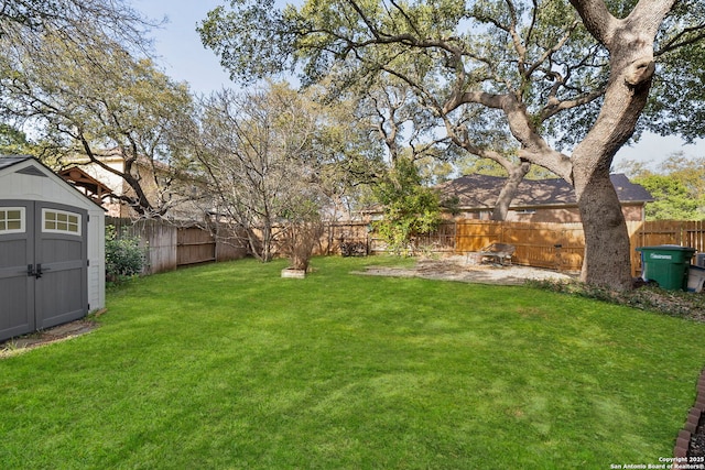 view of yard with a fenced backyard, a storage shed, and an outdoor structure