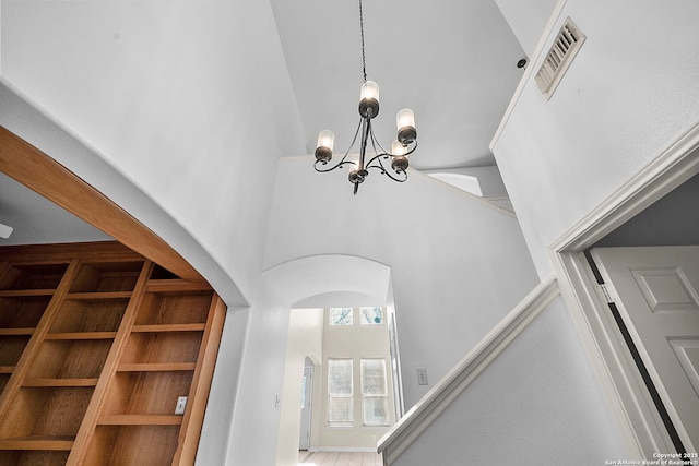 details with arched walkways, visible vents, and a chandelier