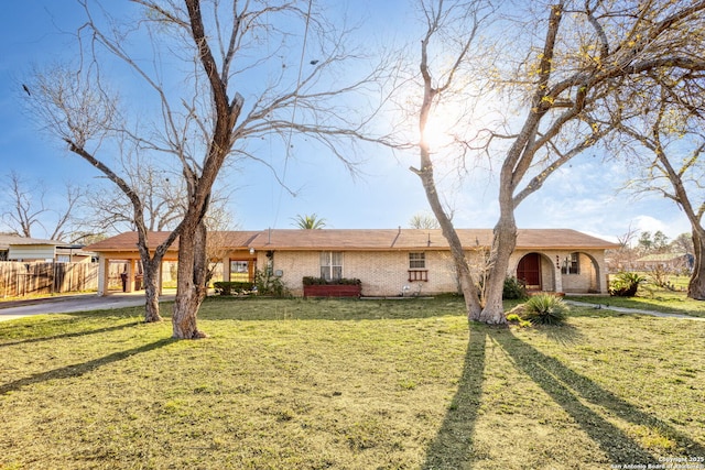 single story home featuring an attached carport, a front yard, fence, and brick siding