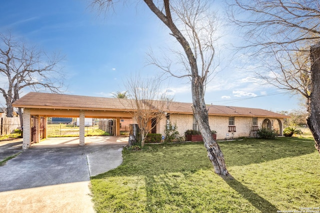 single story home with a carport, fence, concrete driveway, a front yard, and brick siding