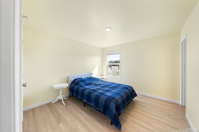 bedroom with light wood-style flooring and baseboards