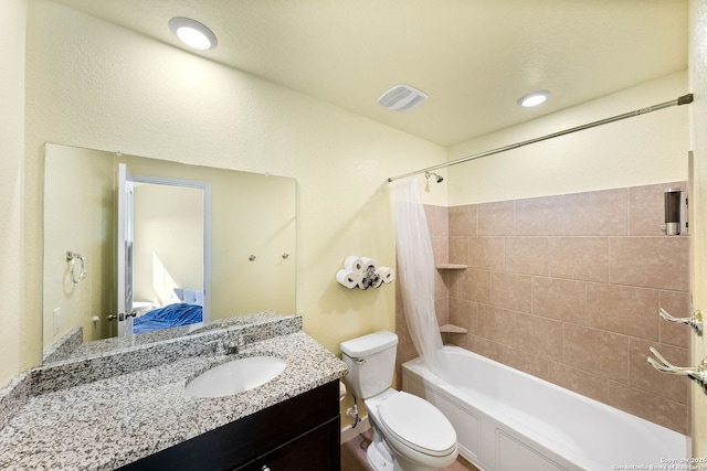 full bathroom with visible vents, shower / bath combo with shower curtain, toilet, vanity, and ensuite bath