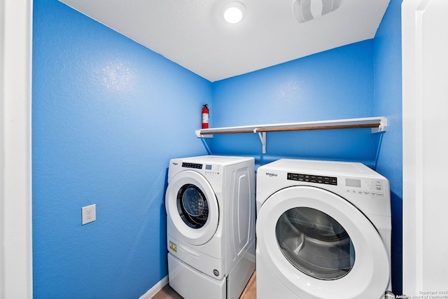 clothes washing area with washer and clothes dryer and laundry area