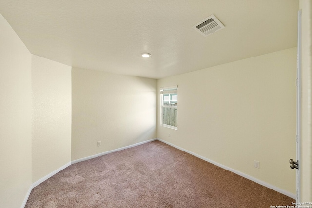 unfurnished room with light colored carpet, visible vents, and baseboards