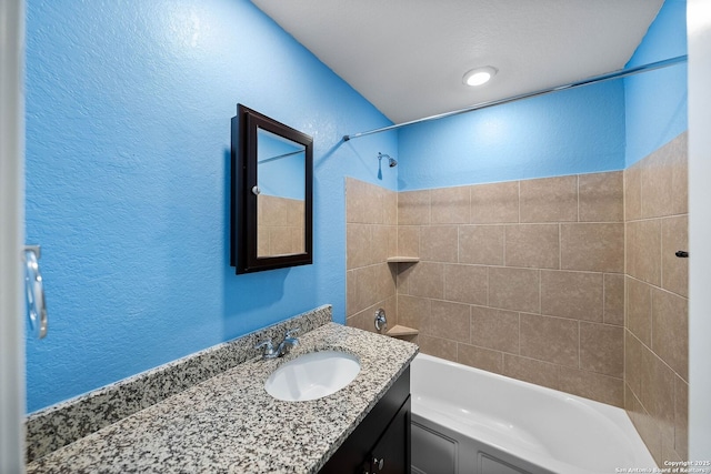 full bathroom featuring vanity, bathing tub / shower combination, and a textured wall