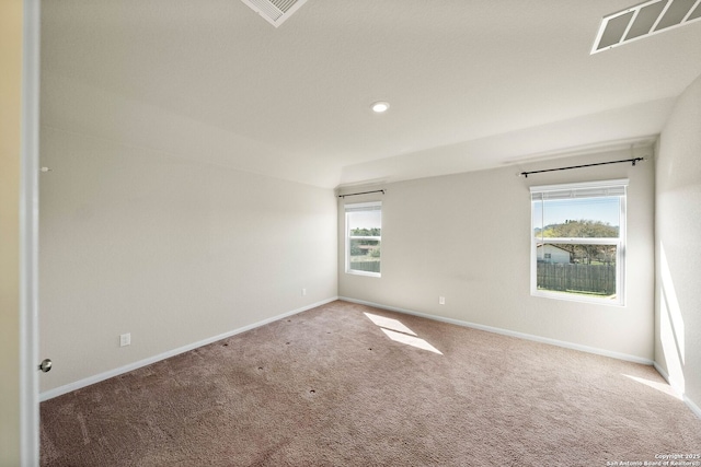 carpeted empty room featuring recessed lighting, visible vents, and baseboards