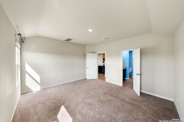 interior space featuring visible vents, baseboards, and vaulted ceiling