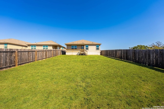 rear view of property with a yard and a fenced backyard