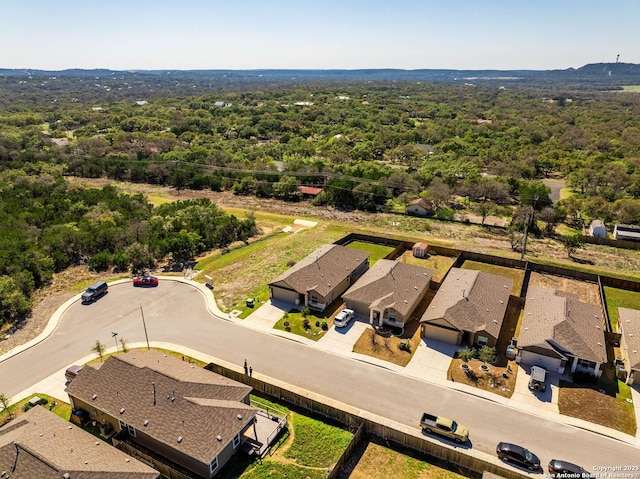 drone / aerial view featuring a forest view and a residential view